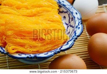 Golden egg strip is Thai desserts made from eggs with Thai style bowl on wooden background