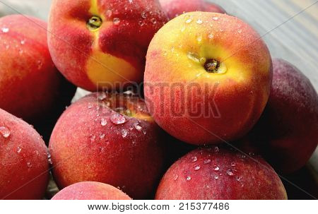 Many Fresh Peach with water drops and shadow on wooden background
