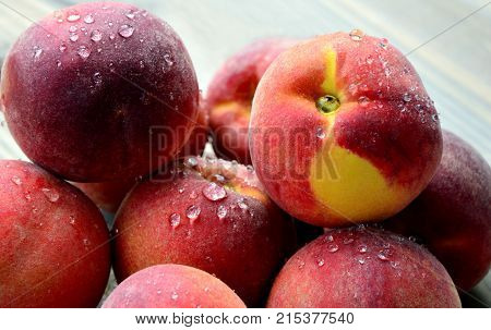 Many Fresh Peach with water drops and shadow on wooden background