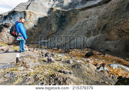 Tourist Near Stream In Gorge In Landmannalaugar