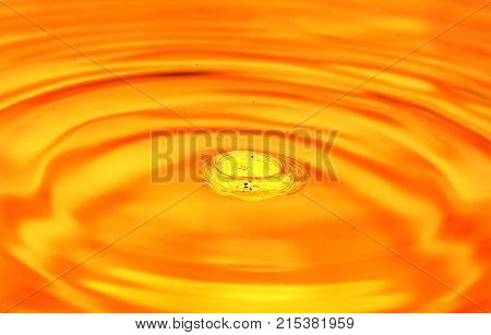 a drop of water falls in a golden water. macro .