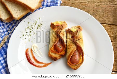 Toasted Hot Dogs and Cheese on white dish and wheat with fresh toast on wooden background