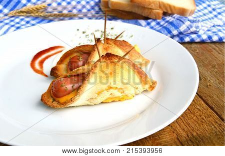 Toasted Hot Dogs and Cheese on white dish and wheat with fresh toast on wooden background