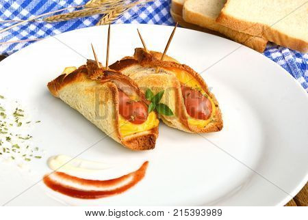 Toasted Hot Dogs and Cheese on white dish and wheat with fresh toast on wooden background