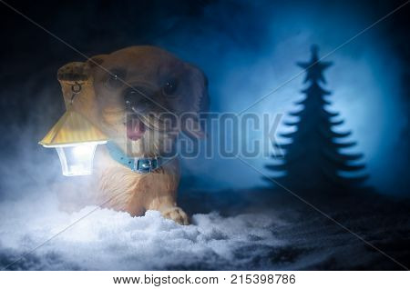 Toy Dog - A Symbol Of The New Year Under The Snow Against The Background Of Fir Branches. Toy's Dog 