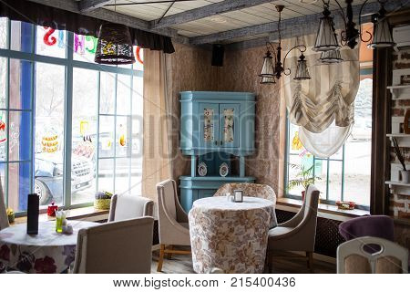 Cafe with vintage furniture and big windows.