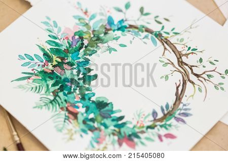 drawing, art, nature concept. on the snowy white paper there is adorable and colorful picture created with watercolores, it is wreath with small flowers and leaves of different coloures