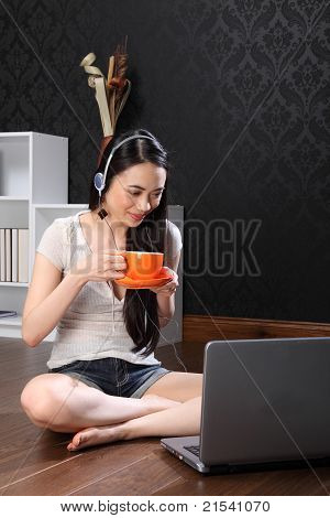 Mooie Chinees meisje het drinken van thee met behulp van Internet