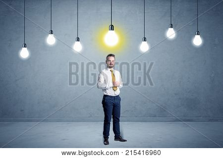 Handsome businessman in an empty space with bulbs above and uninspired face
