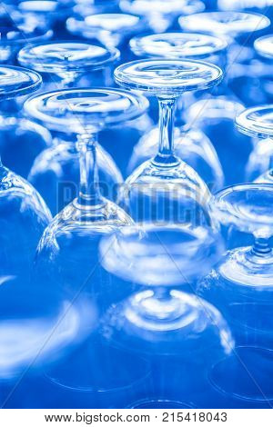 Group of empty wine glass upside down in row blue tone
