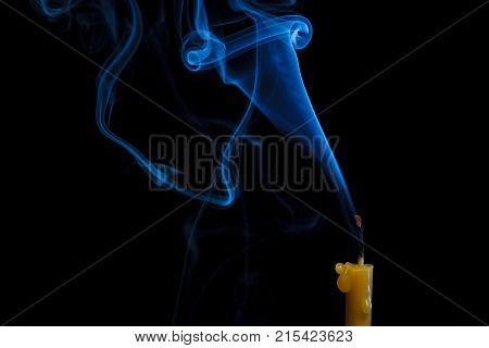 Fantasy blue smoke from the extinguished candles on a black background.