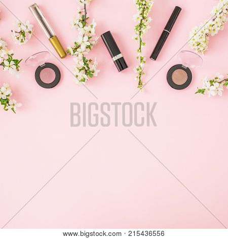 Woman background. Spring flowers and woman cosmetic isolated on pink background. Flat lay, top view.