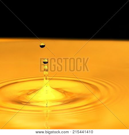 a drop of water falls in a golden water. macro .