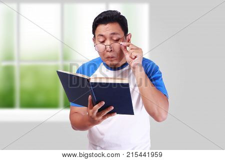 Young Man With Glasses Having Bad Vision When Reading Book
