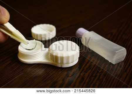 eye lens wear tweezers storage container lenses on the table