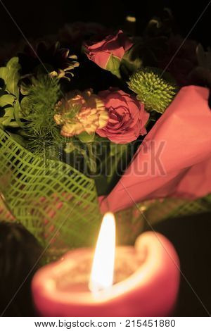 burning candle and a bouquet of flowers. Valentine's day still life.