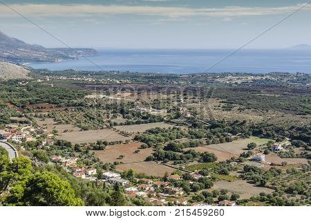 View of plowed fields and Kefalonia coasts near the city of Argostoli with the Ionian sea in the background