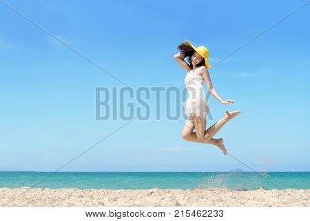Happy asian woman jumping on the beach at the sea in the sunny day. Travel summer concept.