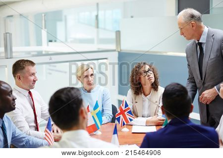 Representatives of g8 countries listening to mature colleague speech at meeting