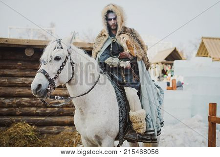 Russia. Moscow.Red square 26 Feb 2017. Carnival Maslenica . warrior winter sitting on a horse and holds her hand on the owl