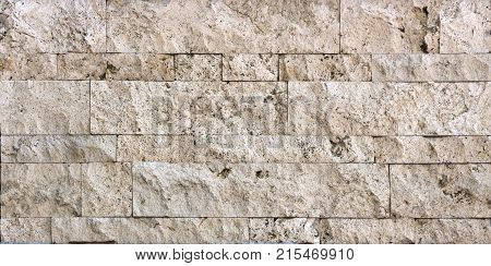 Stone wall texture, travertine tiles facing stone background