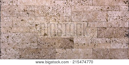 Stone wall texture, travertine tiles facing stone background