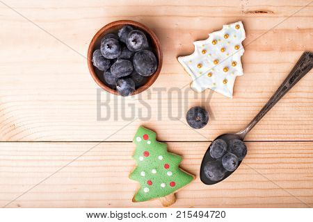 Ginger cookies with green icing fri tree on a light wood Christmas and New Year background. Top view copy space.