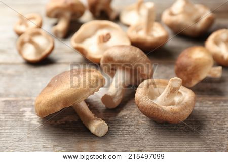 Raw shiitake mushrooms on wooden table, closeup