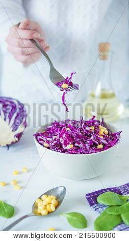 Salad Of Red Cabbage And Corn. Woman's Hand Holds Fork With Salad
