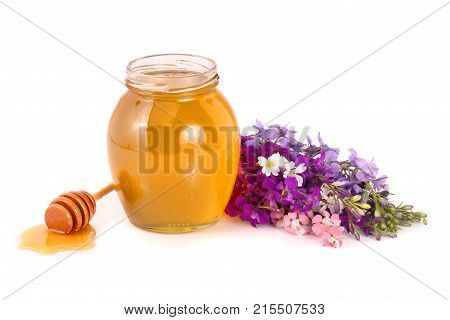 Jar of honey with wildflowers isolated on white background.