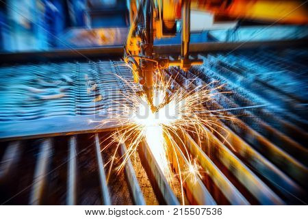 Oxygen torch cuts steel sheet. CNC gas cutting machine. Abstract industrial background, motion blur effect.