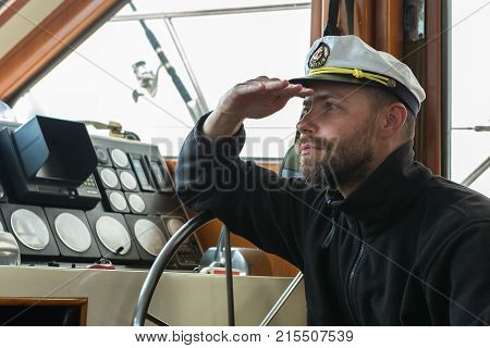 Captain at the helm of a boat going along the Pacific Ocean