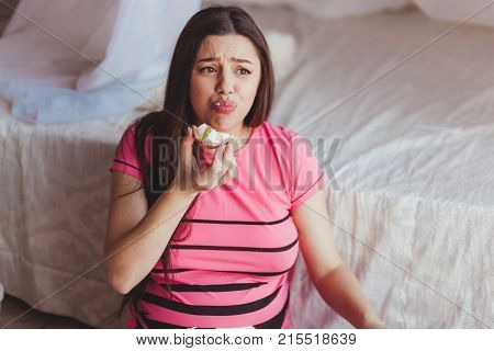 Young disgust female after trying piece of cake, healthy diet concept, pregnancy food.