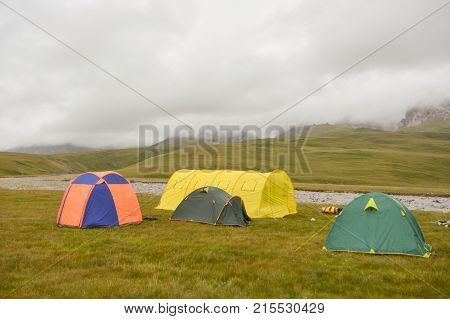 Tourist tent in field camp among montains (mist tend field)