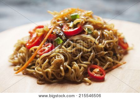 Fried asian instan noodles with bean sprouts, green onion and chili pepper