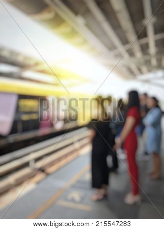 Abstract Blurred Image Of People Waiting For Train Coming And Using Mobile Phone In Electric Sky Tra