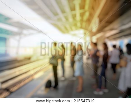 Abstract Blurred Image Of People Waiting For Train Coming And Using Mobile Phone In Electric Sky Tra