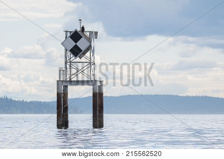 Calm cloudy day. Daymark positioned in West Seattle WA. The bald eagle was a bonus