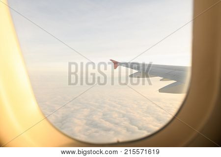 the view from the airplane on the left wing above the clouds concept of vacation flight trip