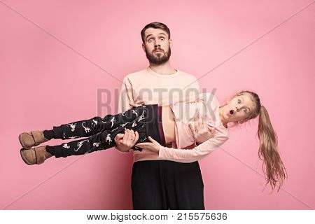 The surprised and cheerful father playing with daughter at pink studio