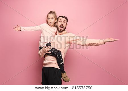 The surprised and cheerful father playing with daughter at pink studio