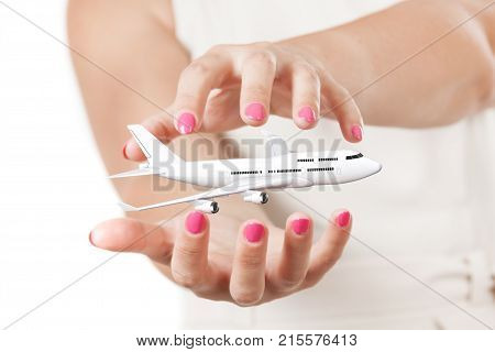 Two Woman Hands Protecting White Jet Passenger's Сommercial Airplane on a white background. 3d Rendering