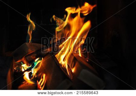 Orange dancing fireflames in the dark fireplace