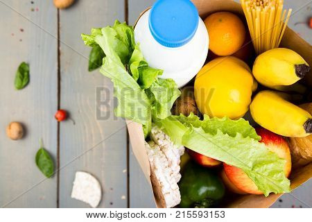 Grocery Shopping Concept. Different Food In Paper Bag On Wooden Background.  Top View.