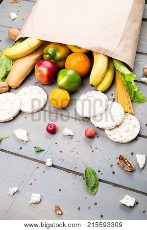 Grocery Shopping Concept. Different Food In Paper Bag On Wooden Background.  Flat Lay.