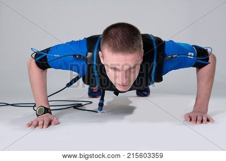 Man In An Electric Muscular Suit For Stimulation Does Push-up.