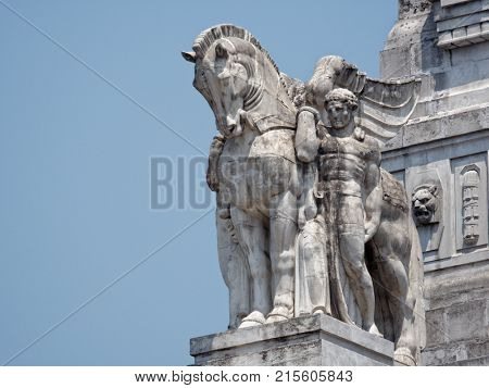 MILAN, ITALY - JUNE 12, 2017: One of statues on the facade of the building of Milano Centrale, the central train station. Designed by architect Ulisse Stacchini, the building was erected in 1912-1931
