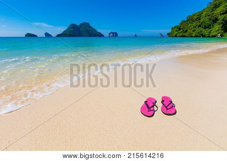 Pink flip flops on shore at Aonang beach during summer