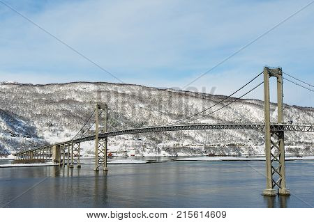 The Tjeldsund suspension road Bridge in winter crossing the Tjeldsundet strait, Troms county, Norway. It is part of a network of bridges that connect islands of Vesteralen and Lofoten to the mainland.