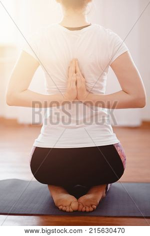 Yoga Concept. Close up woman meditates while practicing yoga in training hall or home.